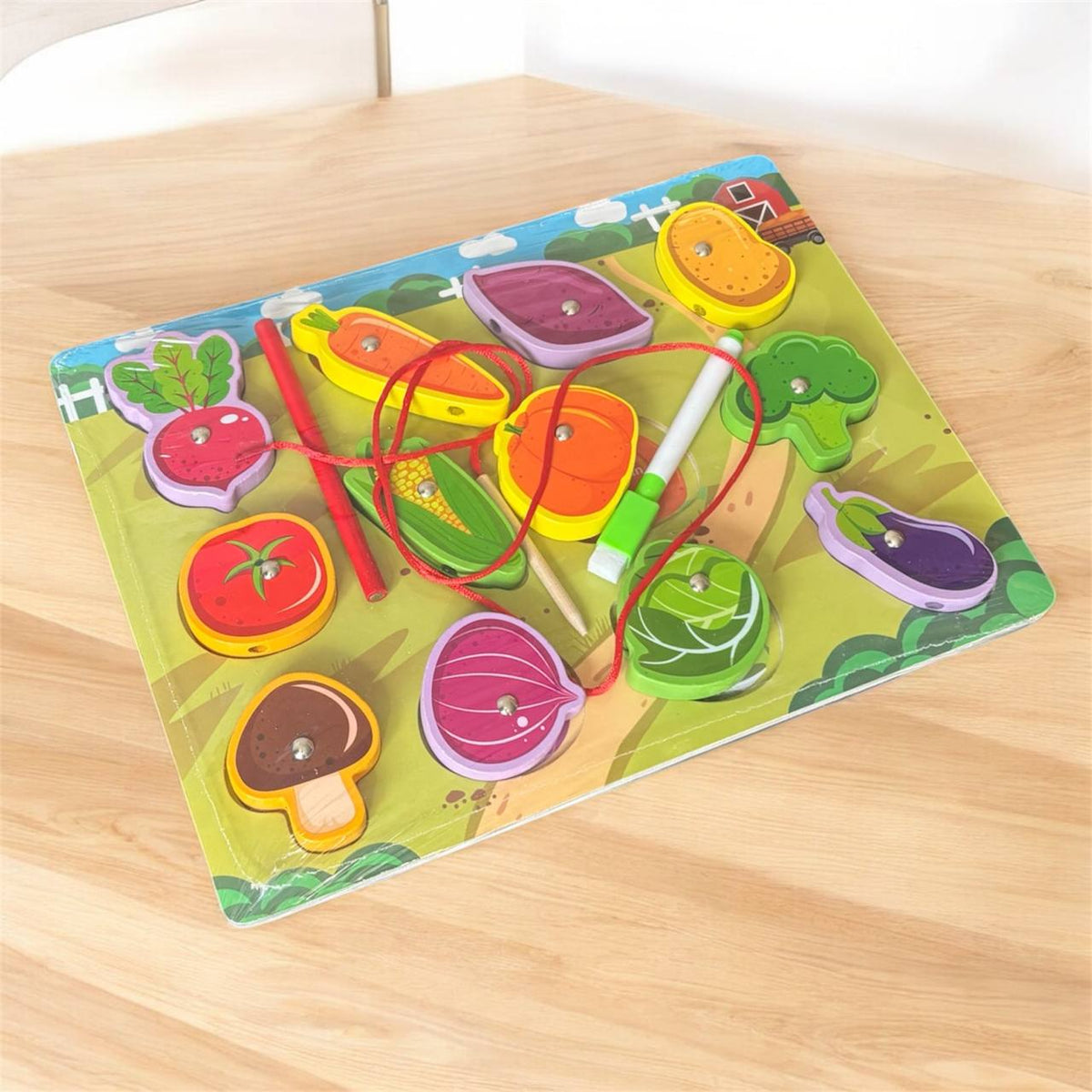 Wooden puzzle with colourful vegetables that a child picks up with a red magnetic stick – photo 2